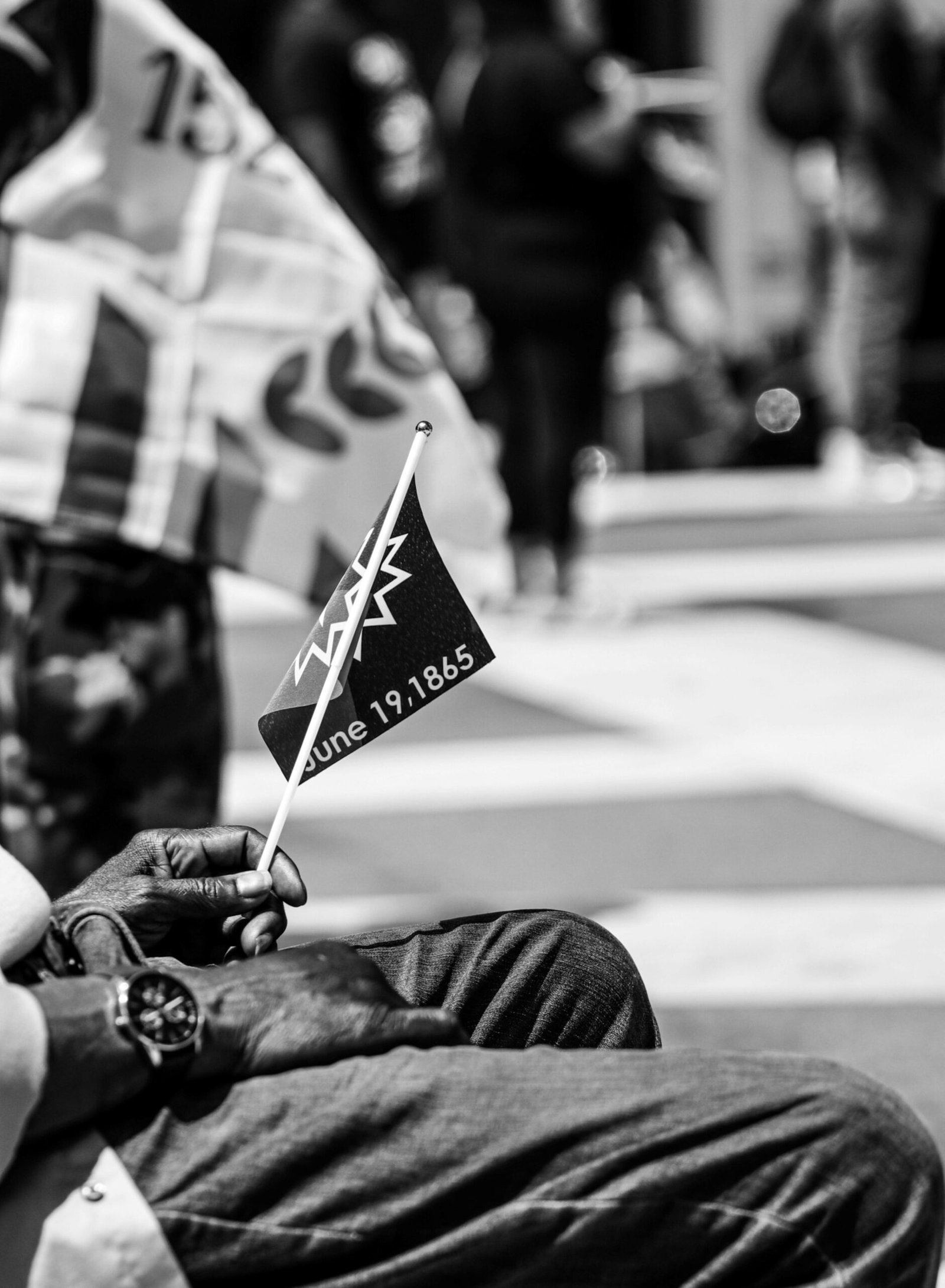 Black and white photo capturing a man holding a Juneteenth flag, symbolizing freedom.